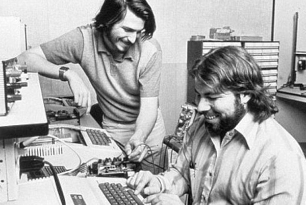 Steve Jobs and Wozniak working on computers in the garage.