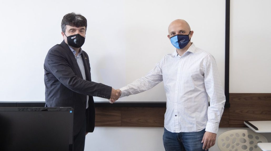 Two men in face masks shaking hands